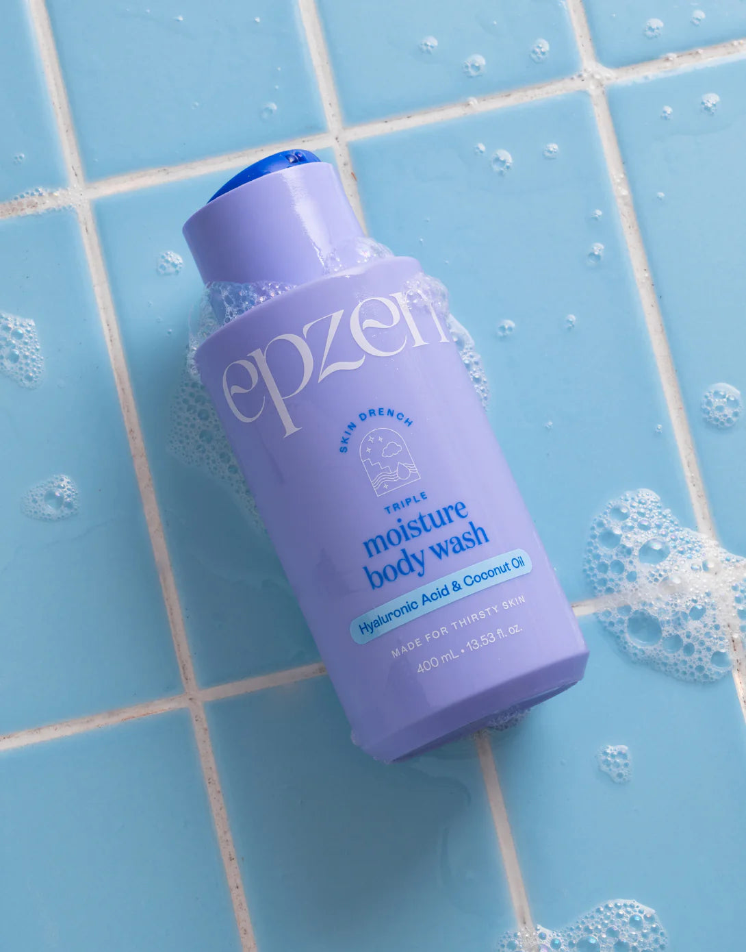 A 400ml blue bottle of Epzen Triple Moisture Body Wash with hyaluronic acid and coconut oil on a white background.