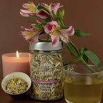 Colorful loose leaf Kintra Glow tea blend with dried rose petals, blue cornflowers, and various herbal ingredients.