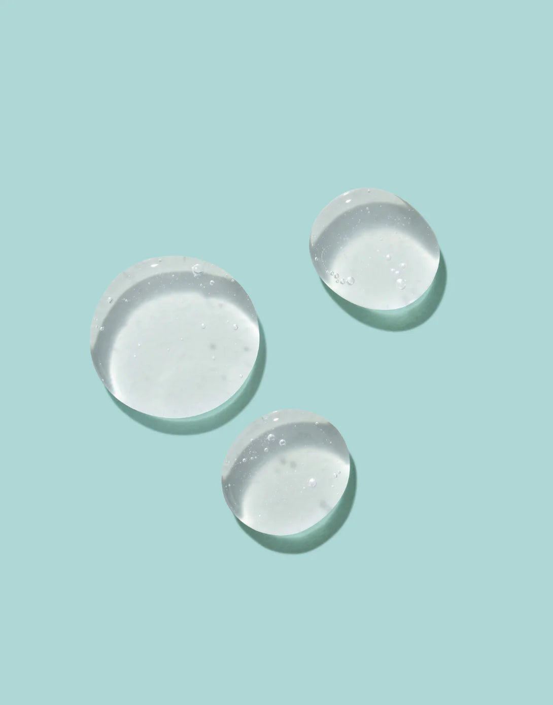 Close-up of clear Epzen Body Wash being poured onto a white surface, showing its smooth, gel-like texture.