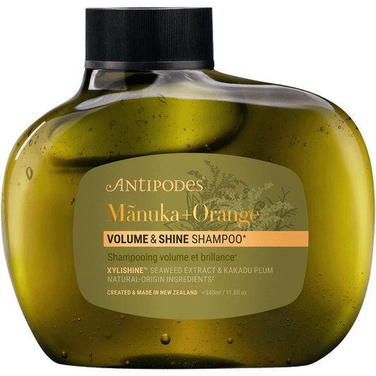 Antipodes Manuka + Orange Volume & Shine Shampoo 340ml bottle with a white pump and botanical label illustrations.