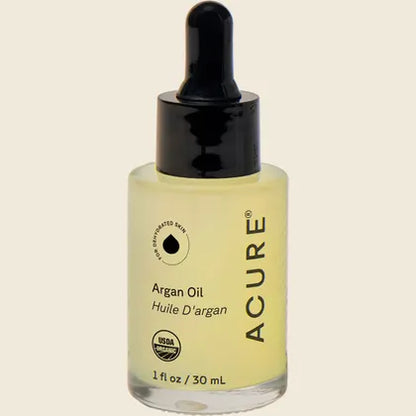 ACURE The Essentials Argan Oil 30ml glass bottle with a yellow and white geometric label on a white background.