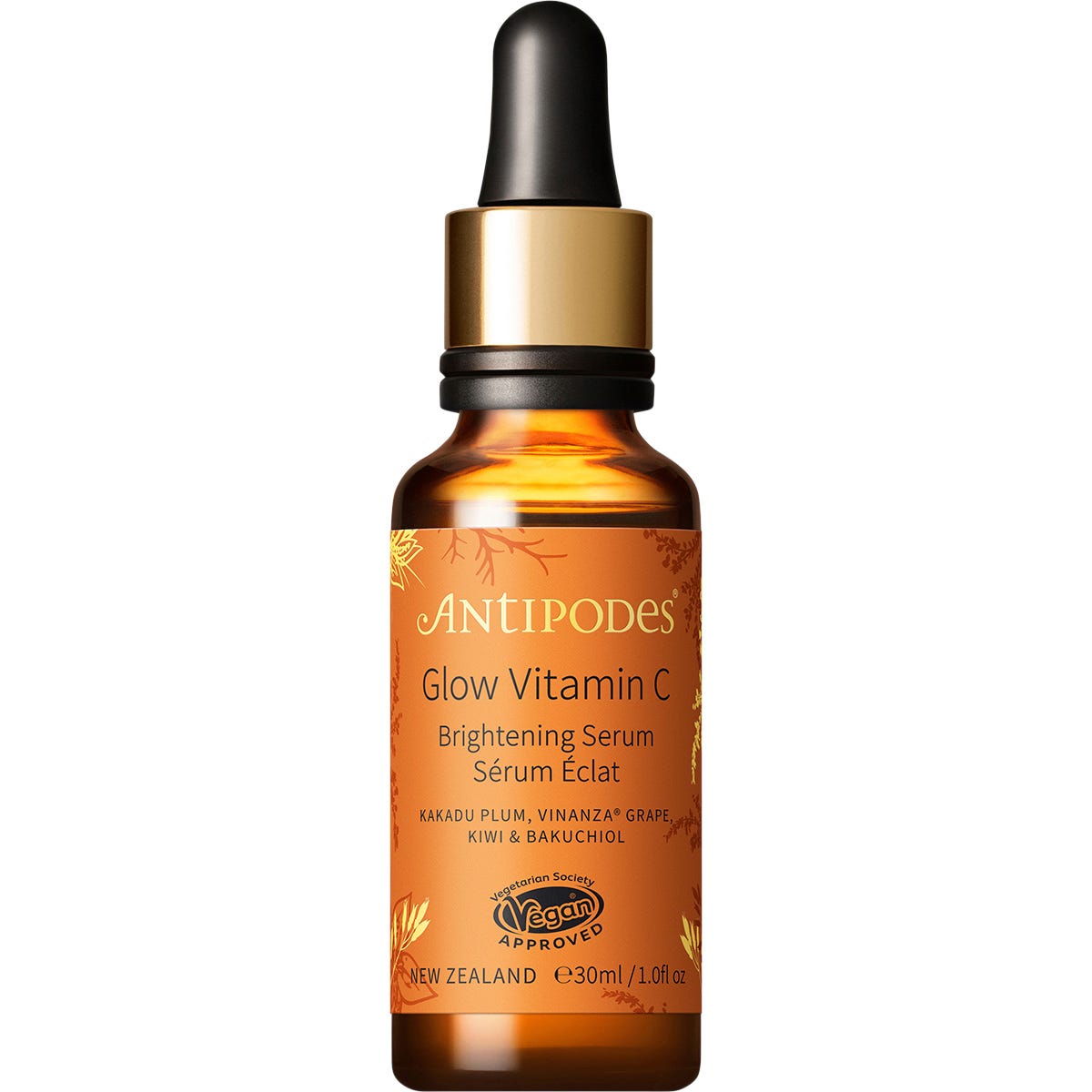 Antipodes Glow Vitamin C serum bottle and gold dropper next to its orange and white box on a white background.