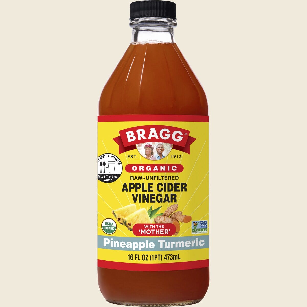 473ml bottle of Bragg Organic Apple Cider Vinegar Pineapple Turmeric Blend with the "Mother" on a white background.