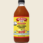 473ml bottle of Bragg Organic Apple Cider Vinegar Pineapple Turmeric Blend with the "Mother" on a white background.