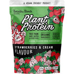 500g pouch of Botanika Blends Strawberries and Cream plant protein with a pink label and botanical illustrations.