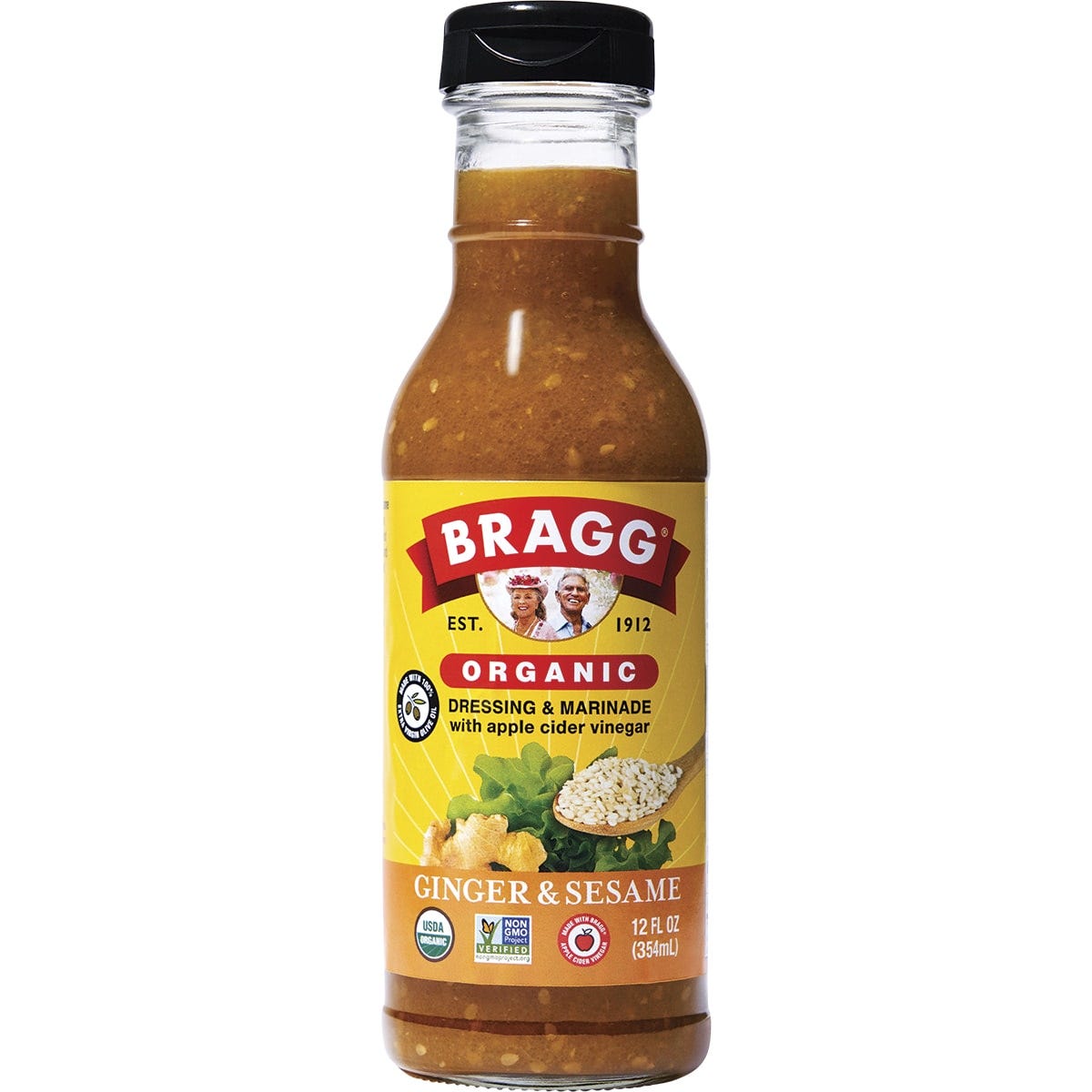 Bragg Ginger and Sesame 354ml glass bottle of organic salad dressing and marinade on a white background.