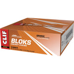 Close-up of an orange-flavored CLIF Bloks Energy Chew packet with a "25mg Caffeine" label on a white background.