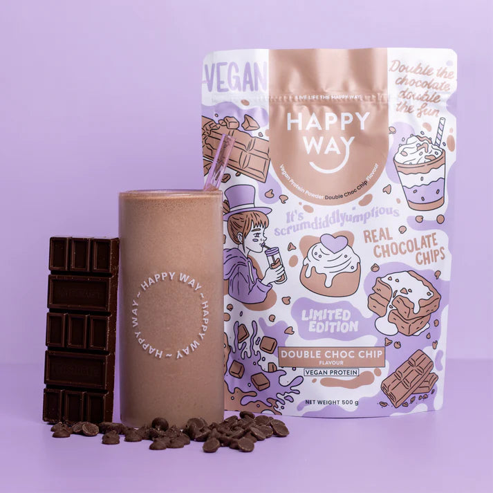 Chocolate smoothie topped with chips in a glass beside a Happy Way Double Choc Chip Vegan Protein Powder bag.