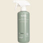 Green bottle of toilet foaming cleaner with white spray nozzle on a beige background