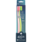 Pink and green Grin Pro Ultimate Gentle Care ultra-soft toothbrushes in a two-pack display box with recycled handles.