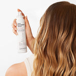 Close-up of a person with long, wavy blonde hair styled with Giovanni Texturizing Spray for volume and definition.