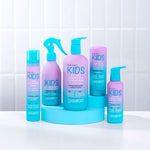 A smiling child with curly hair being styled with Giovanni Kids Curl Activator Spray.