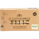 Twenty bamboo clothes pegs with metal springs in a recycled cardboard box on a white background.