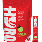 Hyro Lemon Lime Electrolyte box next to a prepared glass of citrus drink, a sachet, and fresh lemon and lime slices.