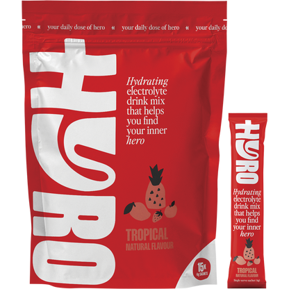 Box of Hyro Tropical Electrolyte Sachets with one individual sachet leaning against it on a white background.