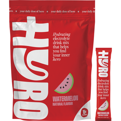 Hyro Watermelon Electrolyte box with a single sachet, a glass of pink liquid, and fresh watermelon slices.