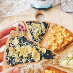 A 150g jar of EveryOrganics EveryMite Reduced Aussie Salt savory spread on a blue background with a wooden spoon.