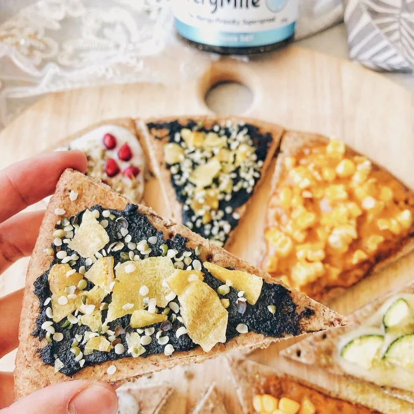 A 150g jar of EveryOrganics EveryMite Reduced Aussie Salt savory spread on a blue background with a wooden spoon.