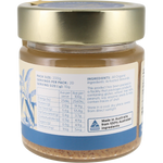 A jar of almond butter with a gold lid and a white and blue label showing nutritional information and ingredients, photographed against a white background.