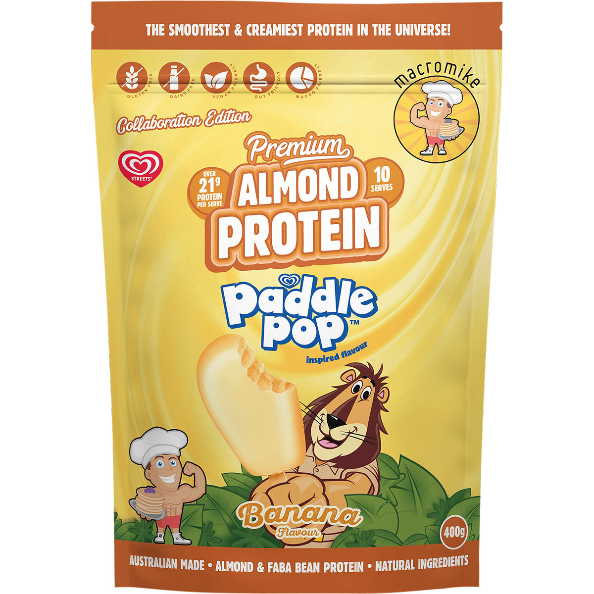 A 400g stand-up pouch of Macromike Paddle Pop Banana Protein powder, featuring a bright yellow and orange design with cartoon illustrations of a banana and a lion.