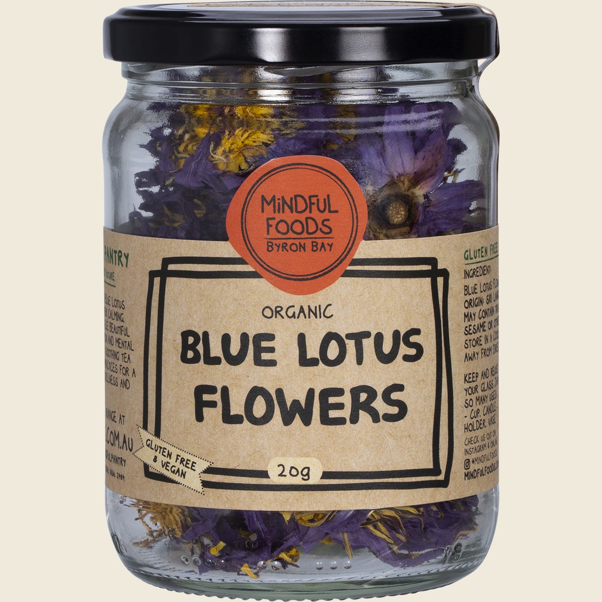 Dried whole blue lotus flowers in a glass jar by Mindful Foods, labeled organic and sustainably grown.