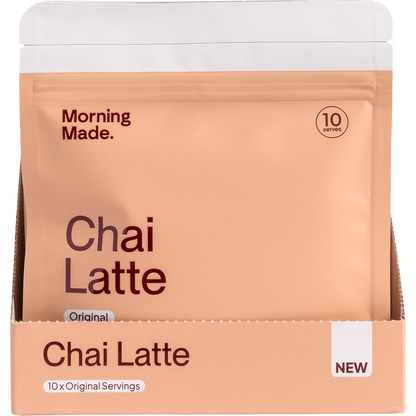 A white and orange display box for Morning Made Original Chai Latte containing 12 individual 50g sachets.