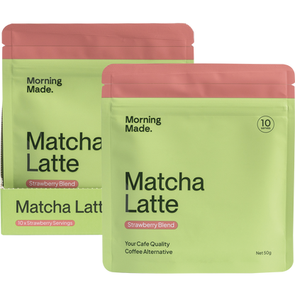 Pink 50g pouch of Morning Made Strawberry Matcha Latte next to a white box and a glass of the prepared iced drink.