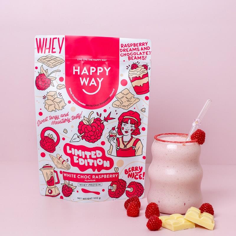 Scoop of White Choc Raspberry Whey Protein Powder with fresh raspberries and white chocolate pieces on a white background.