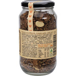 Top view of a glass jar of Mindful Foods Cacao Brain Power Granola showing dark chocolate clusters and seeds.