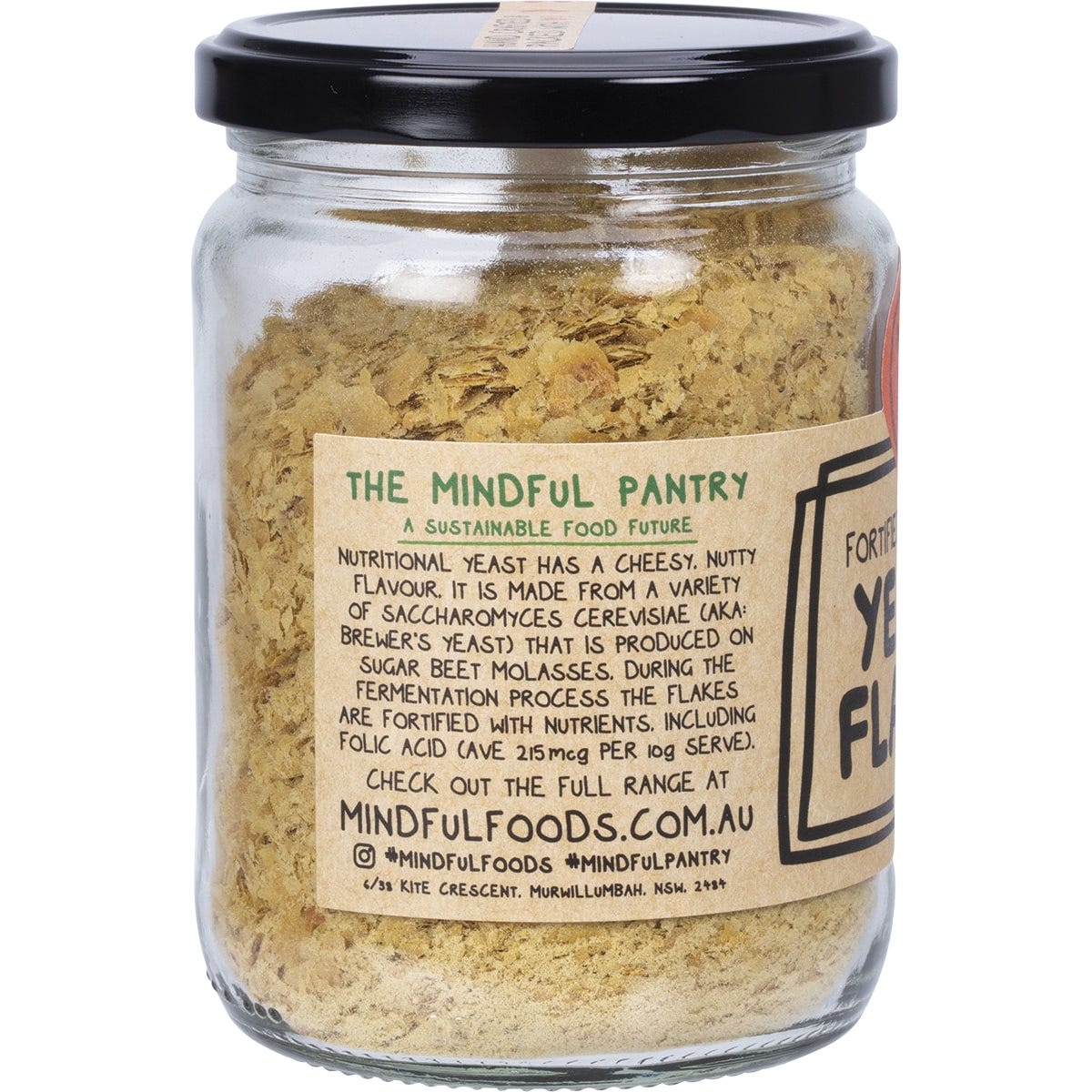 Mindful Foods yeast flakes in a glass jar with a black and gold label against a white background.