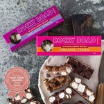 Close-up of Organic Times Milk Chocolate Rocky Road showing marshmallows, almonds, and berry jellies on a white background.
