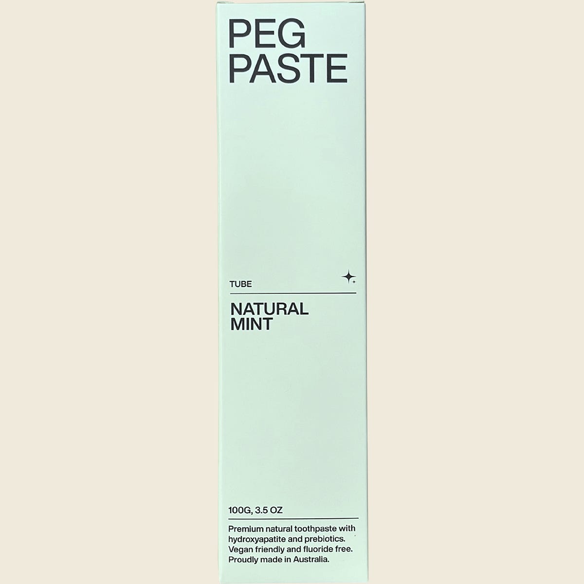 Front of Peg Paste Natural Mint toothpaste box featuring a white design, mint leaf illustration, and 100g weight.