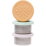Three Ever Eco mini stainless steel containers with pastel lids used for snacks and dips on a wooden surface.