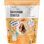 Sourdough Mumma 20g gluten-free sourdough starter packet on a marble surface with a glass jar of bubbly starter.