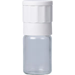 Salt of the Earth ceramic salt and spice grinder with a clear glass body and white lid on a white background.