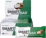 Box of 12 Smart Protein Bars in Coconut flavor next to a single wrapped 60g bar and a pile of desiccated coconut.