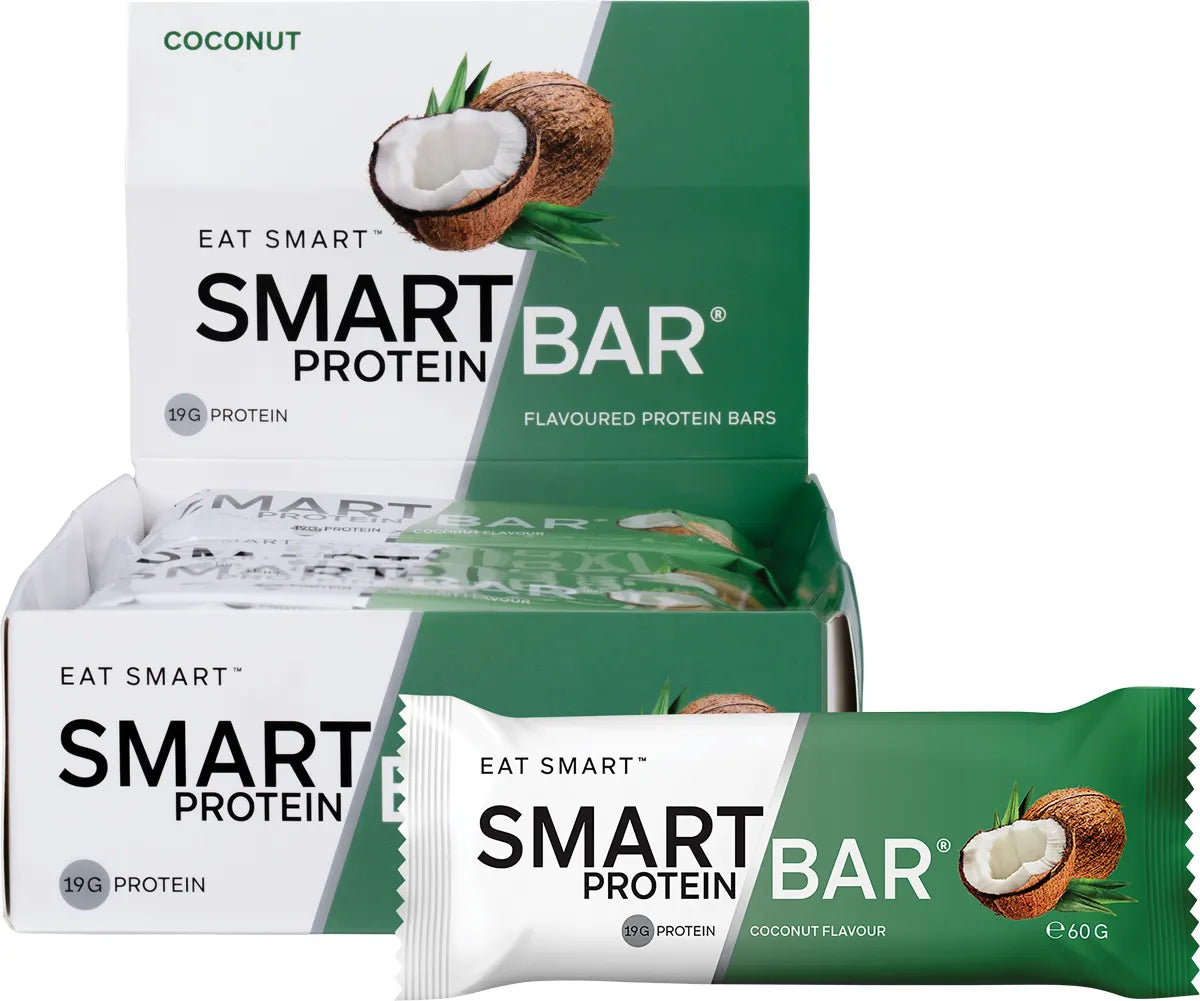 Box of 12 Smart Protein Bars in Coconut flavor next to a single wrapped 60g bar and a pile of desiccated coconut.