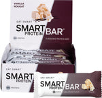 A box of 12 Smart Protein Bars in Vanilla Nougat flavor, including one unwrapped bar showing a chewy, textured center.