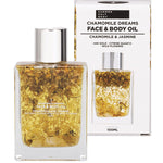 Summer Salt Body 24K gold face and body oil bottle with chamomile flowers and citrine quartz next to its gift box.