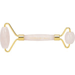 Rose quartz facial roller with a dual-ended design and polished pink stones on a white background.