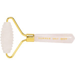 Rose quartz spiky facial roller with a gold-toned metal frame and a smooth pink handle, isolated on a white background.