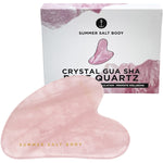 Rose quartz gua sha tool and its white gift box with botanical illustrations and instructions.