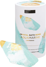 Aquamarine bath bomb with an embedded crystal, shown next to its white and blue patterned box on a white background.