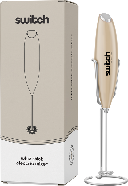 Beige Switch Nutrition Whiz Stick electric mixer shown with its storage stand and product packaging.
