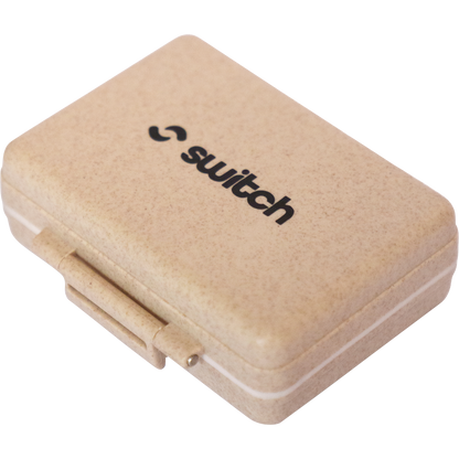Wheat-colored 9-grid pill organizer with a black Switch Nutrition logo on the lid.