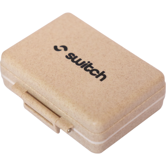 Wheat-colored 9-grid pill organizer with a black Switch Nutrition logo on the lid.