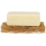 Safix natural coconut fiber soap rest holding a white soap bar on a bathroom sink next to a small plant.