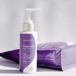 A 200ml bottle of Amazing Oils Magnesium Sleep Lotion with dried lavender and chamomile flowers on a white background.