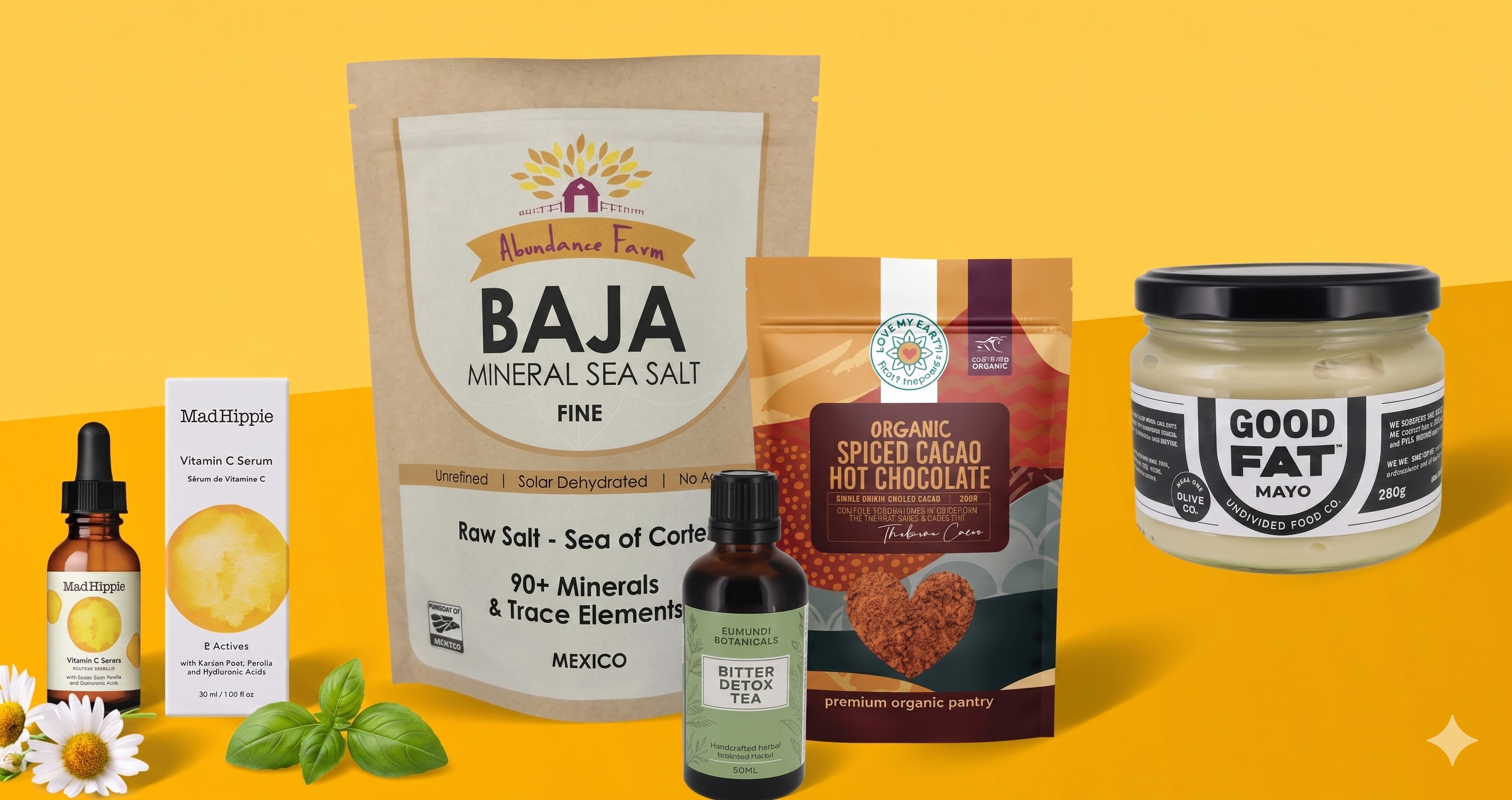 Collection of health and wellness products including a bag of Baja mineral sea salt, a jar of Good Fat mayo, and other items on a yellow background.