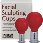 Two clear silicone facial sculpting cups of different sizes shown with their retail packaging and a face map card.